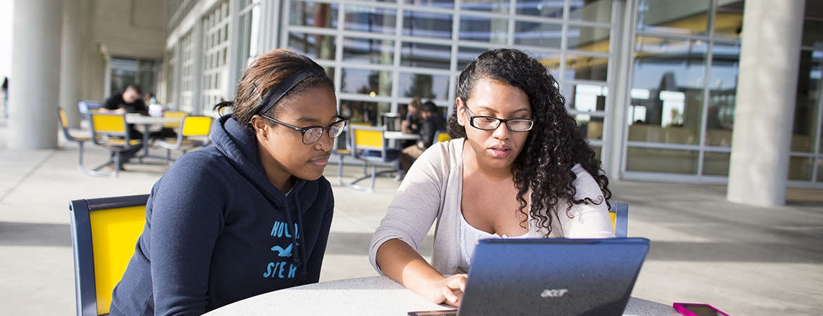 Photo of two students studying in front of Kolligian Library